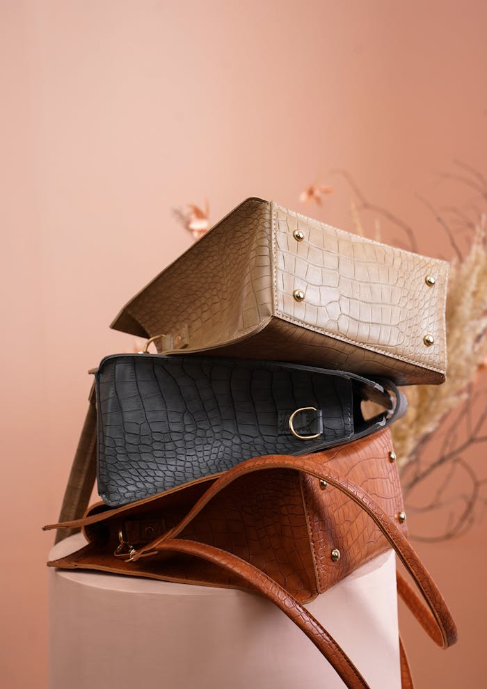 Stacked leather bags in neutral tones showcasing elegance and texture.